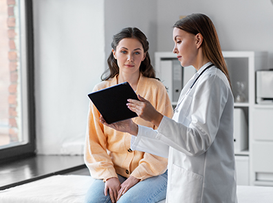 Ärztin zeigt Patient etwas auf einem Tablet