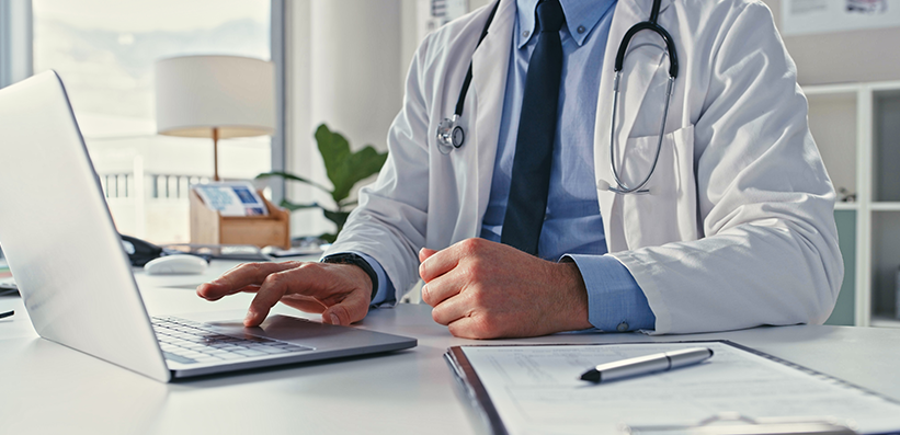 Arzt mit Stethoskop am Laptop – Symbolbild für eCME-Fortbildung zu atopischer Dermatitis