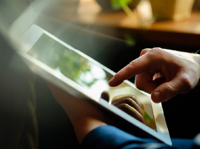 Mann bedient Ipad im Sitzen