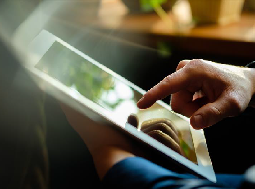 Mann bedient Ipad im Sitzen