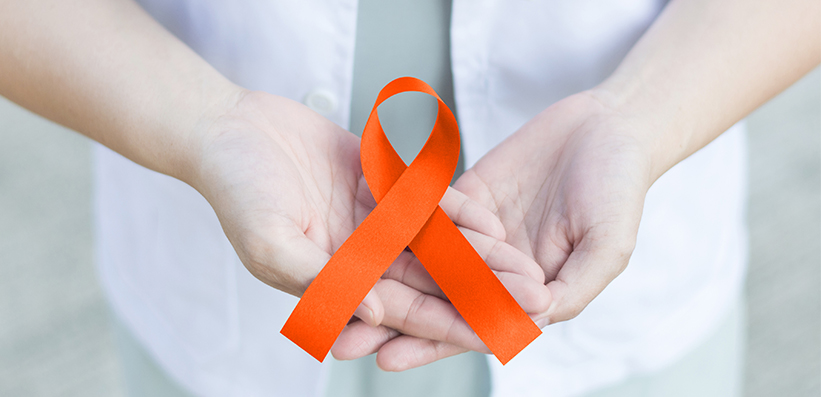 Arzt hält eine orangene Schleife in der Hand: Therapiegebiet Multiple Sklerose